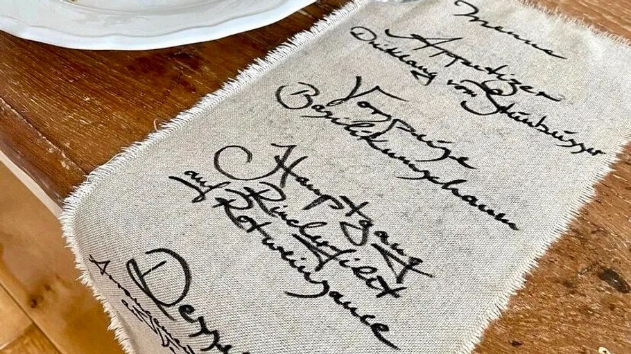 Fabric napkin with handwritten menu on table.