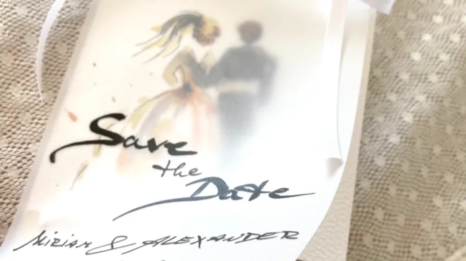 Wedding save-the-date card on lace fabric.