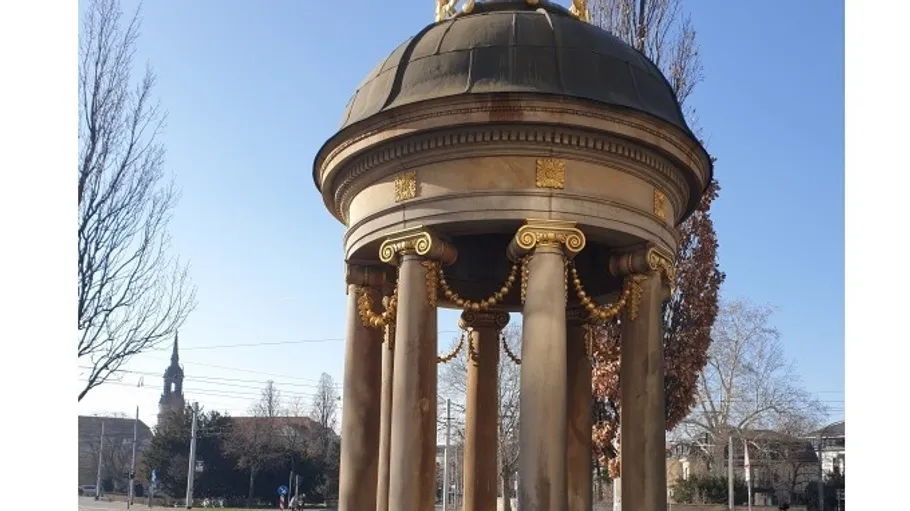 Verzierter Pavillon mit Kuppel in städtischer Umgebung.