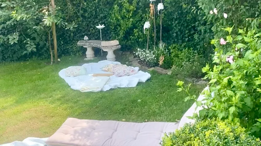 Garden setup with pillows and flowers.