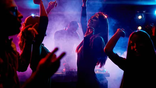 People dancing in a smoky nightclub
