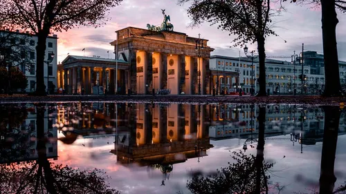 Brandenburg Gate reflection at dusk in Berlin.