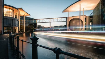 Modern building with light trails, evening.