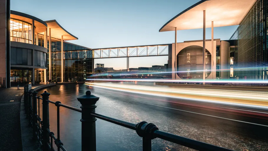 Modern building with light trails, evening.