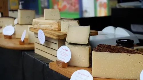 Verschiedene Käsesorten auf einem Marktstand.