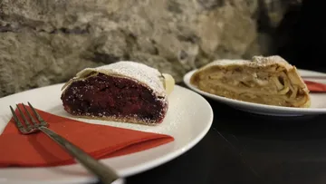 Two slices of strudel on white plates.
