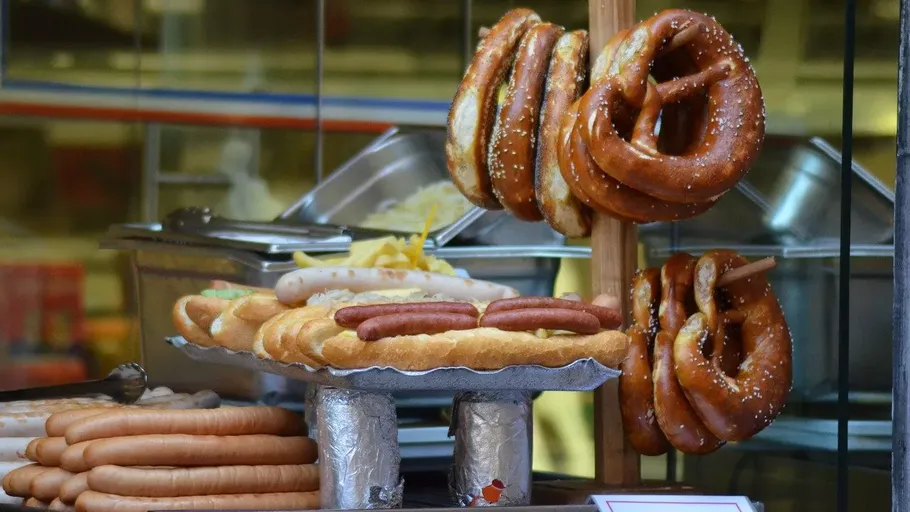 Pretzels and sausages displayed in a shop window.
