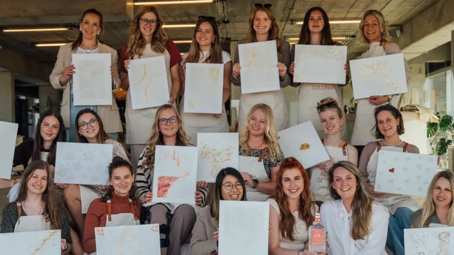 Gruppe von Frauen zeigt ihre Kunstwerke innen.