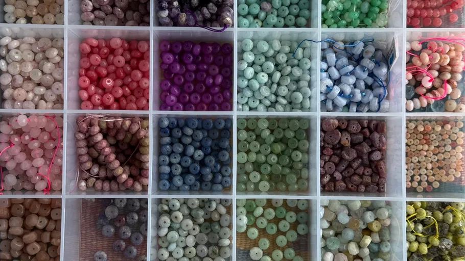 Colorful beads organized in grid compartments.