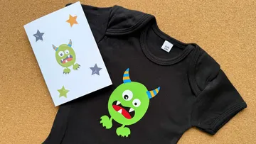 Grünes Monster auf schwarzem Shirt und Karte.