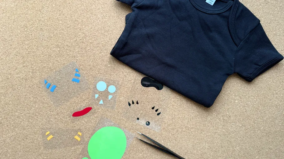 Black shirt with stickers on corkboard.