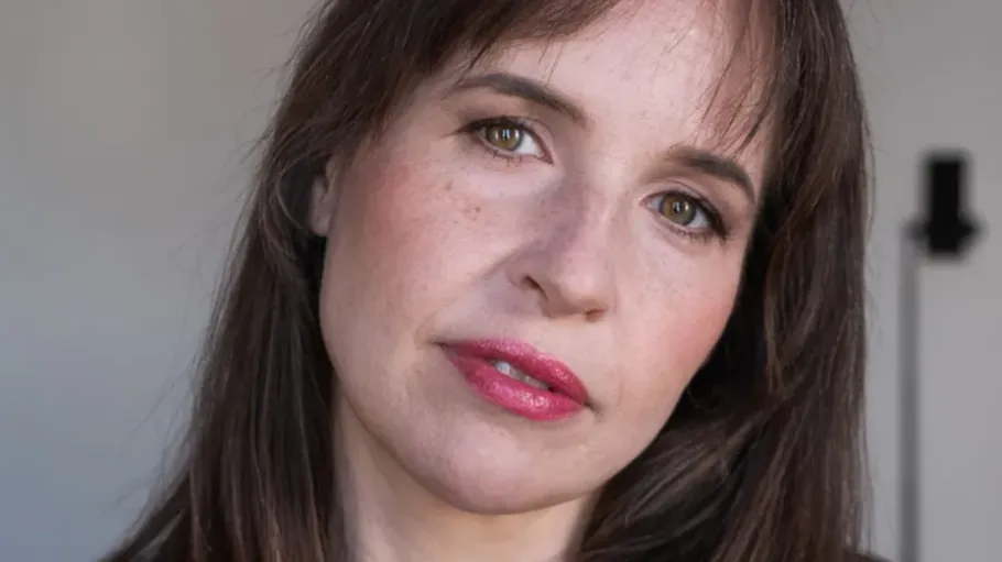 Frau schaut sanft, unscharfer Hintergrund.