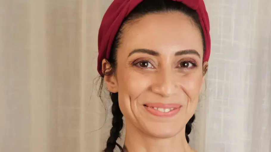 Lächelnde Frau mit geflochtenem Haar drinnen.