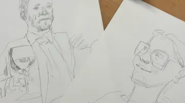 Skizzen von zwei Personen auf Papier, Tischhintergrund.