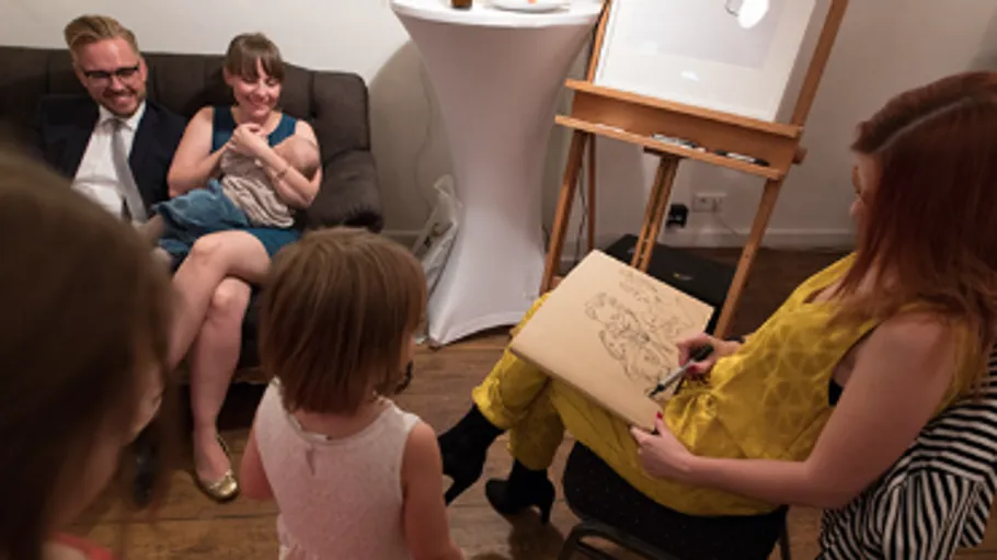 Artist drawing caricature for seated couple.