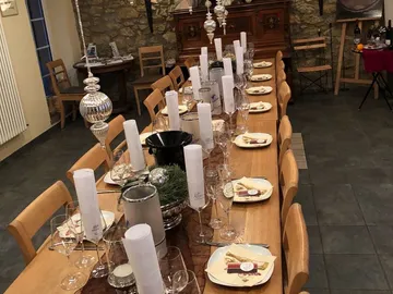 Long wooden table covered with glasses and plates in a restaurant.