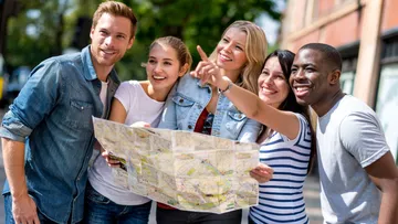 Group holding map, smiling outside.