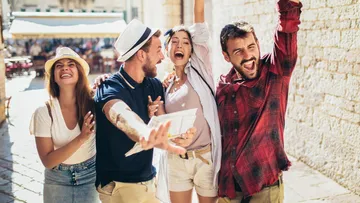 Gruppe Freunde feiert draußen in der Sonne.