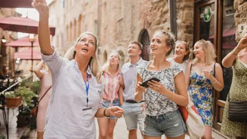 Group of tourists exploring historic European street.