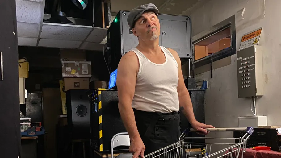 Man in cap with shopping cart indoors.