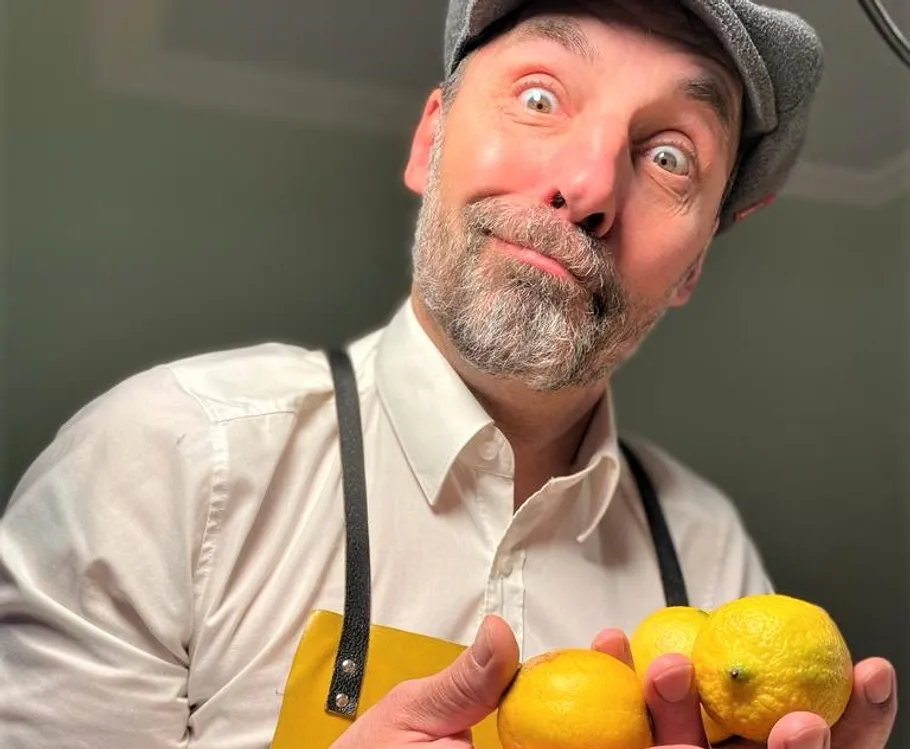 Mann hält Zitronen, zieht lustiges Gesicht drinnen.