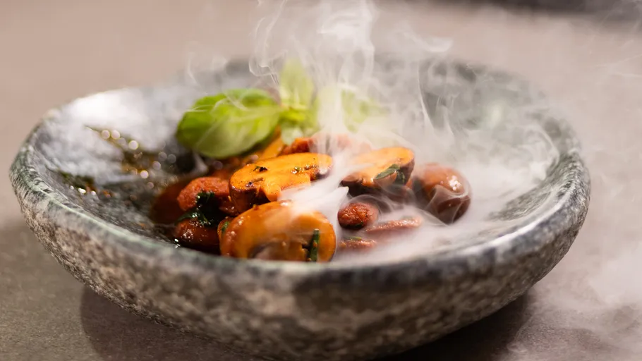 Champignons dampfen in einer Steinschale.