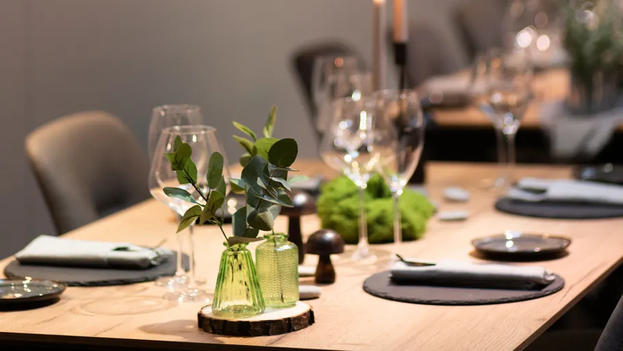 Elegantly set dining table with greenery.
