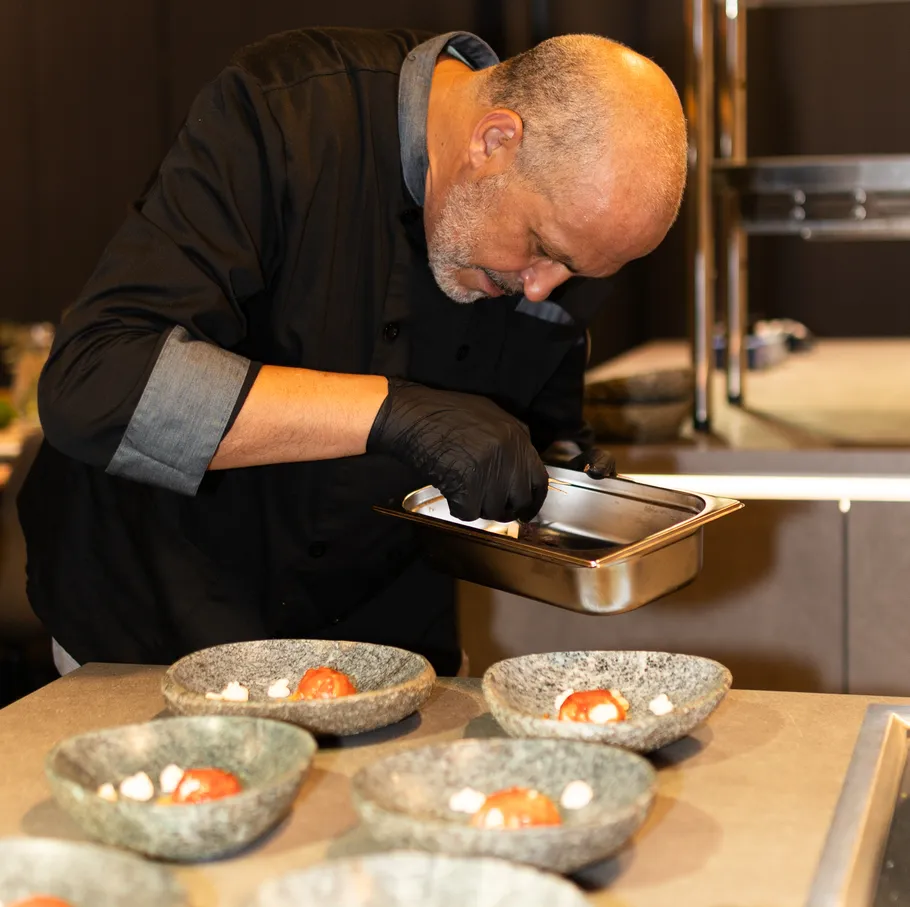 Chef garnishing dishes in a kitchen.
