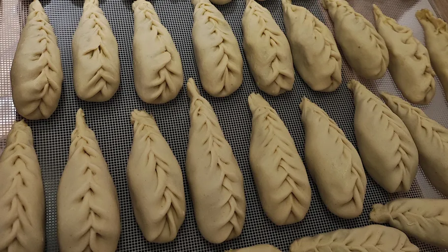 Dough shapes arranged on a baking tray.
