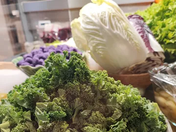 Fresh kale and cabbage in a market display.