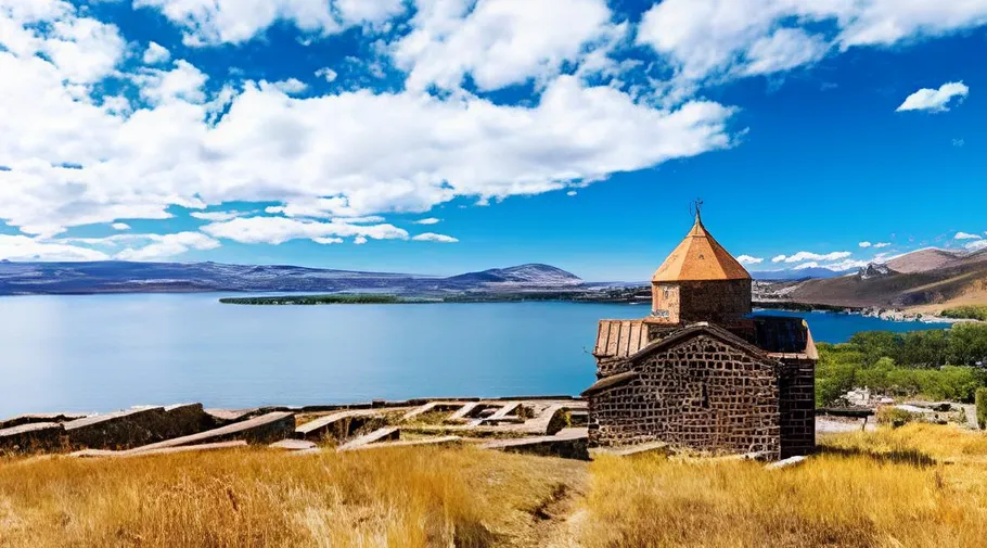 Church near lake with mountains and blue sky.