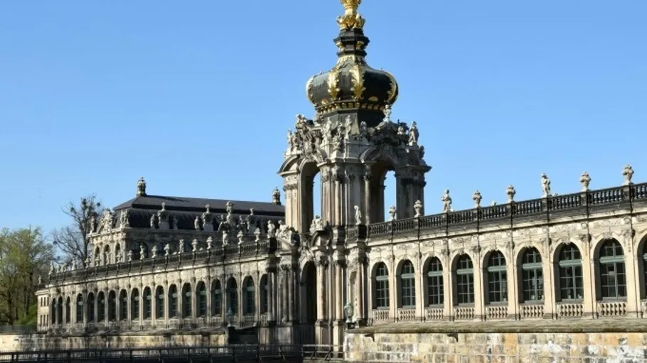 Baroque building with golden crown, clear sky.