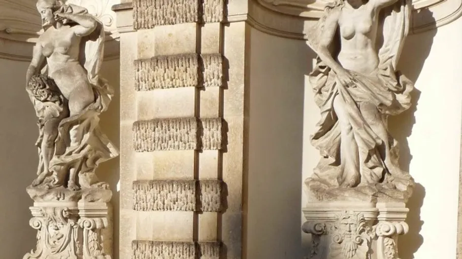 Two stone statues in an architectural setting.