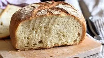 Fresh bread loaf on a wooden board.