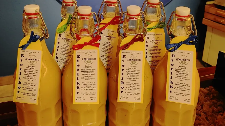 Bottles of egg liqueur with labeled tags.