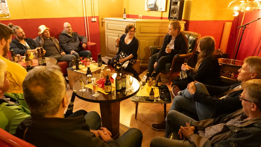 Personen sitzen und reden in einem gemütlichen Raum.