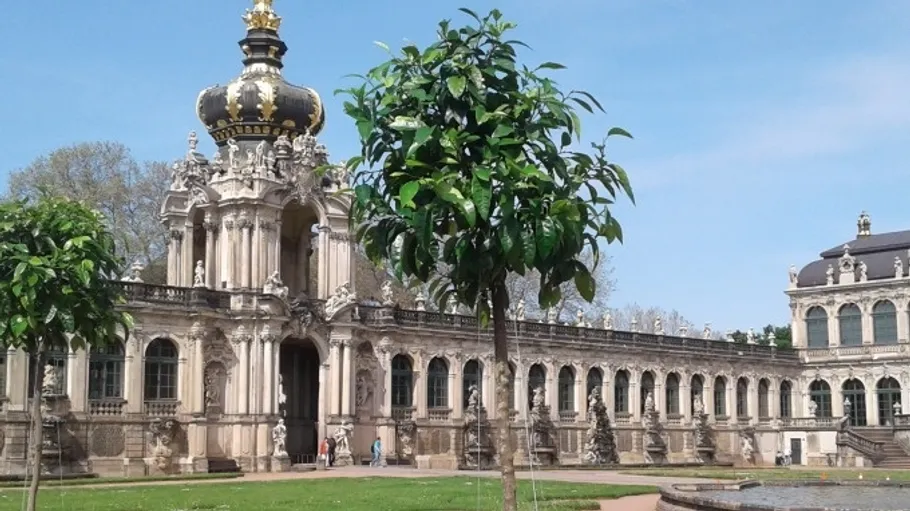 Baroque building with a crowned dome, garden view.