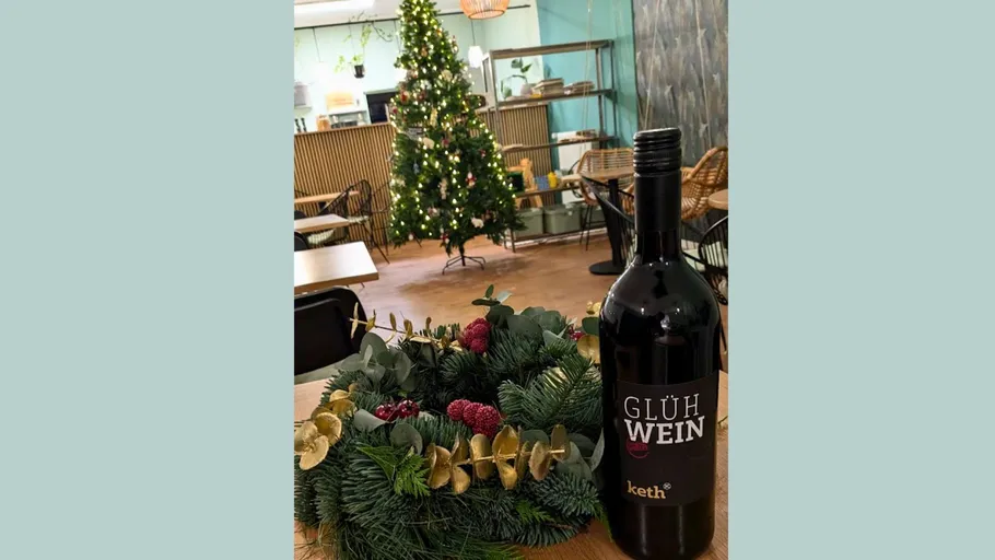 Glühwein bottle and wreath, festive room.