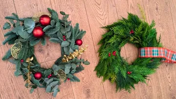 Two Christmas wreaths on wooden floor.