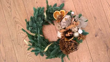 Festive wreath on wooden floor.