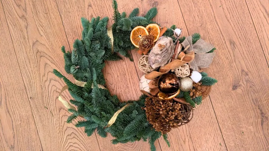 Festlicher Kranz auf Holzboden.