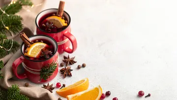 Two mugs of mulled wine with spices.