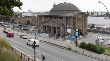 Historic ferry terminal by the river, bustling street.