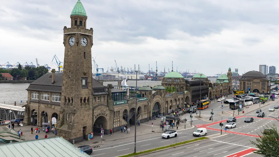 Hafengebäude mit Uhrturm, bewölkter Himmel.