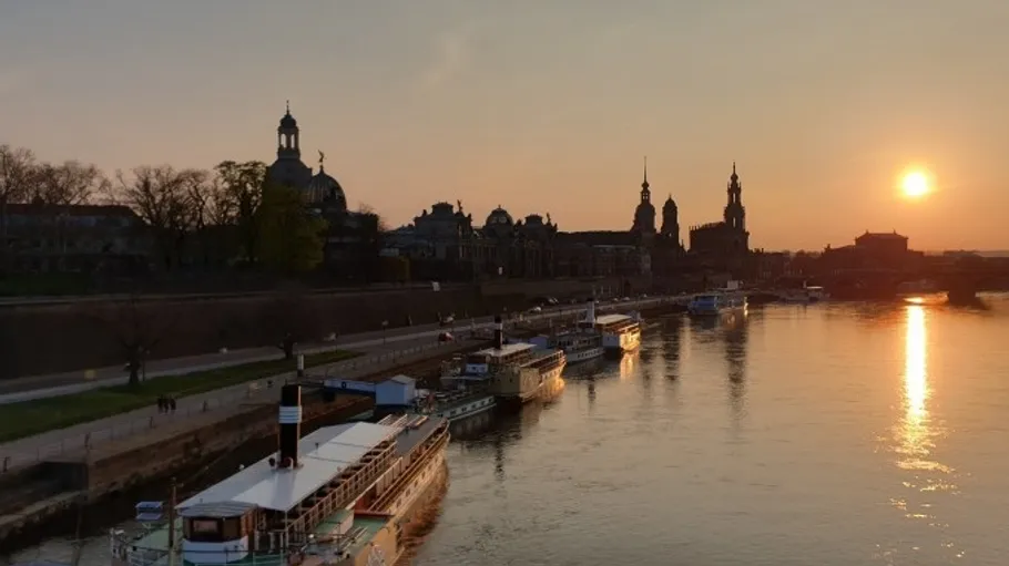 Boats docked along a river at sunset.