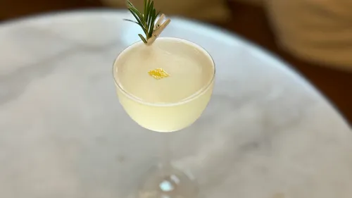Cocktail mit Garnierung auf einem Marmortisch.