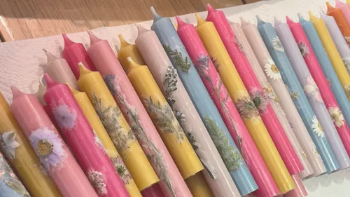 Bunte Kerzen mit Blumendesigns auf Papierhandtuch.