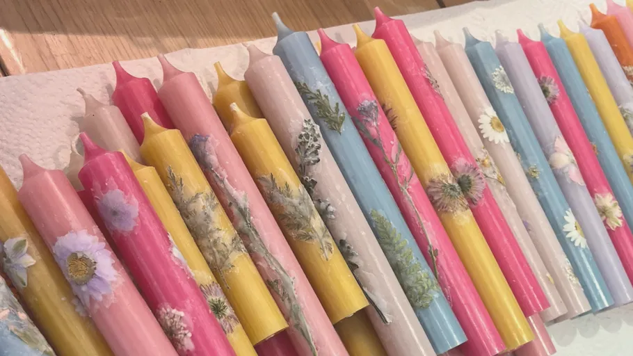 Bunte Kerzen mit Blumendesigns auf Papierhandtuch.