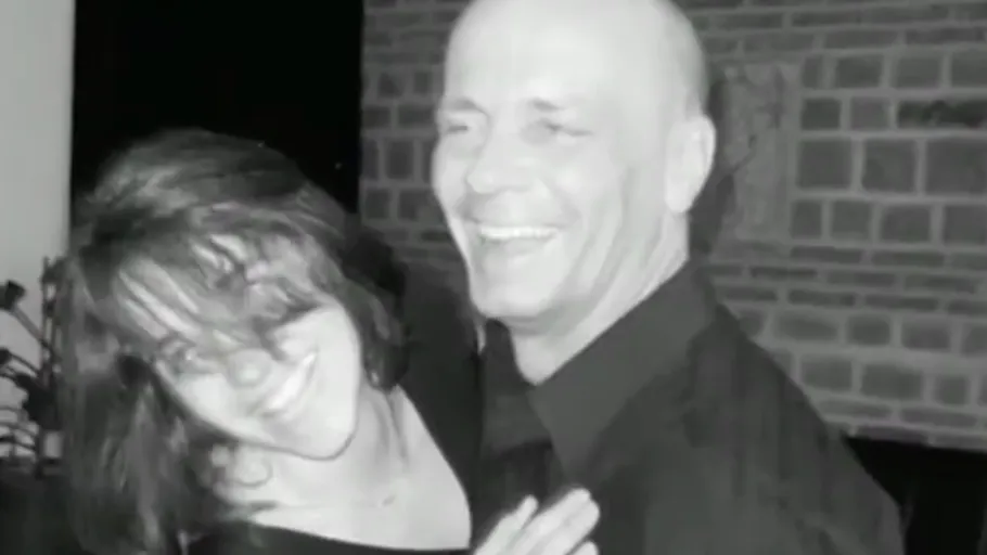Laughing couple embracing indoors.