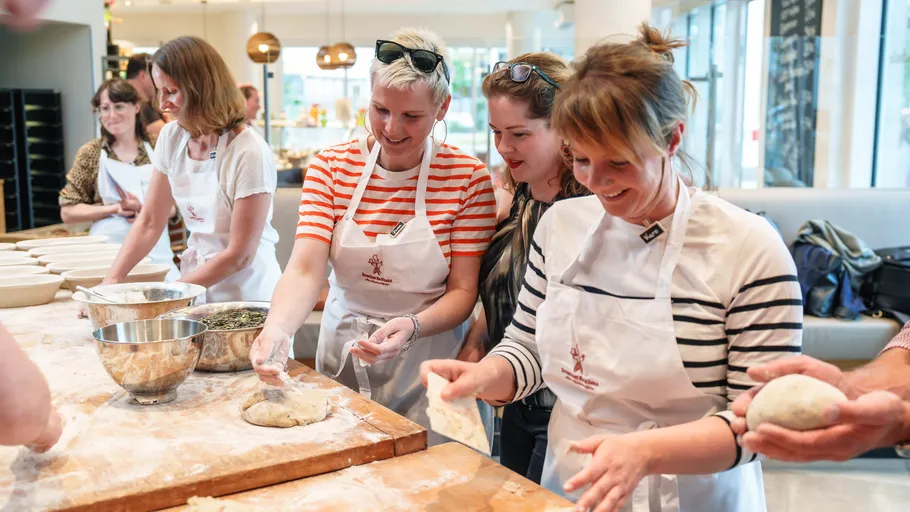People baking bread in a kitchen class.